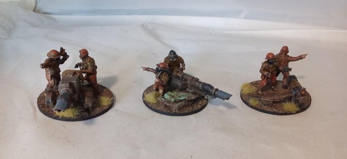 Three sets of heavy weapon teams, manned by soldiers in orange. Two lascannons, and one heavy bolter. Thier uniforms aren't very uniform, and neither is thier kit.