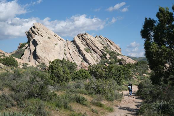 A person strolling along some recognizable rock formations used as a film set for many productions.