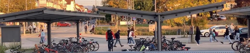 Radfahrende am überdachten Fahrradparkplatz an der S-Bahn