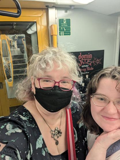 Two people on a train in front of an ad poster for stray kids dominate concert in Sydney