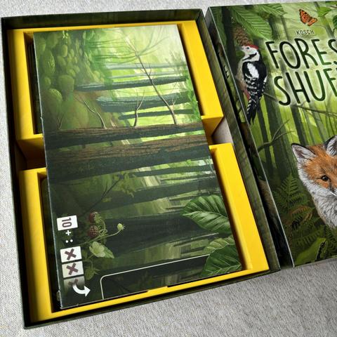 Yellow insert in the Forest Shuffle box, at the top there is a special cut out for the board with the board in it. Leaving enough room at the top for rules