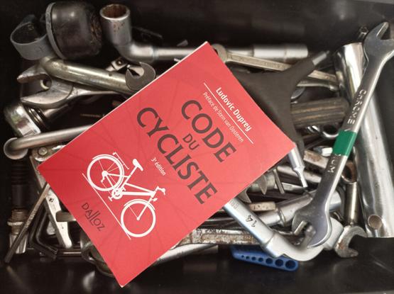 Illustration : Un Code du Cycliste Dalloz dans une boîte pleine d'outils