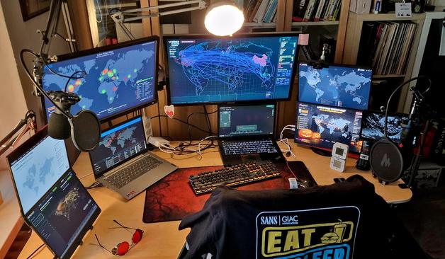 workdesk with multiple monitors and two laptops