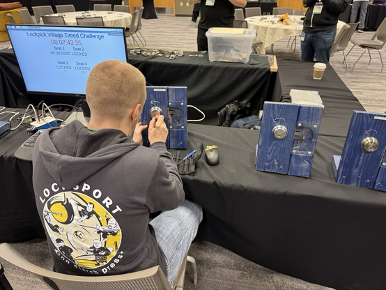 Someone picking a lock at a timed lock competition