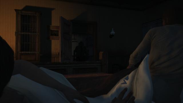 Screenshot of Red Dead Redemption in which a bad-looking man appears in the center of the image in the frame of a door in the background of the shot, while a woman (Abigail) and a man (John) appear in the foreground; left and right respectively