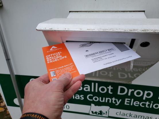 Picture of a election ballot being dropped off at a ballot box in Oregon. My State is 100% vote-by-mail.