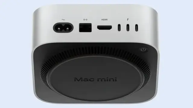 An image of the new M4 Mac Mini tilted to see the underside. The emphasis is that the power button is on the underside in the right corner of the bottom side in the image.