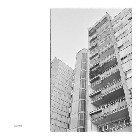 Man sieht die Fassade eine Wiener Gemeindebaus aus den 1970er Jahren. Der Karlheinz-Hora-Hof wird jetzt durch einen vorgelagerten Gemeindebau verdeckt, der alte Bau wirkt trotz seines Alters immer noch futuristisch.