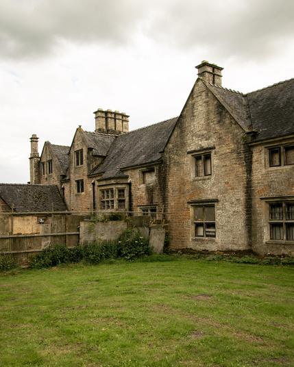 Old buildings in a grass field.