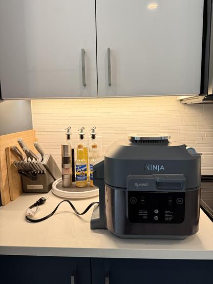 Air fryer that is not plugged in because there are oil and vinegar bottles blocking the outlet.