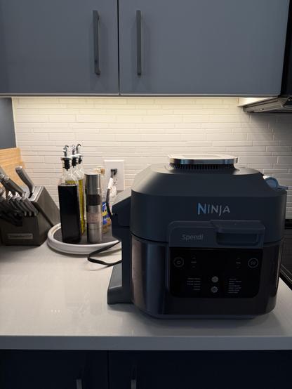Air fryer that IS plugged in because there are oil and vinegar bottles on a lazy Susan that has been turned so the outlet is accessible.