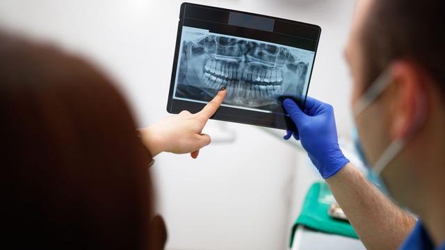 Two people looking at a dental x-ray
