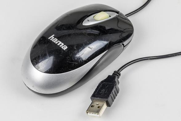 Links die Maus , schwarzer Deckel, silberne Basis, rechts das Kabel mit USB-Stecker