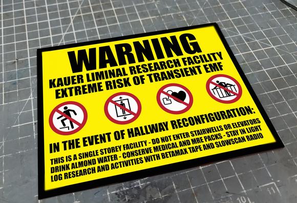 A yellow metal sign with back text stating: 
WARNING
Kauer Liminal research facility
Extreme risk of transient EMF
In the event of a hallway reconfiguratiom
This is a single storey facility, do not enter stairwell or elevators
Drink almond water, conserve medical and MRE packs, stay in light
Log research and activities with betamax tape and slowscan radio

The sign has four ISO warning icons - do not step on platforms, do not use elevator, no pacemakers, do not climb barrier