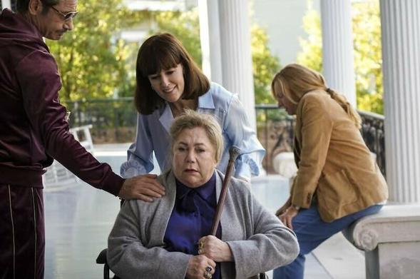 David Duchovny and Rosemarie DeWitt compete to care for Kathleen Turner while Toni Collette struggles in the background. They are on a broad southern porch with columns and lush growth outside the porch.