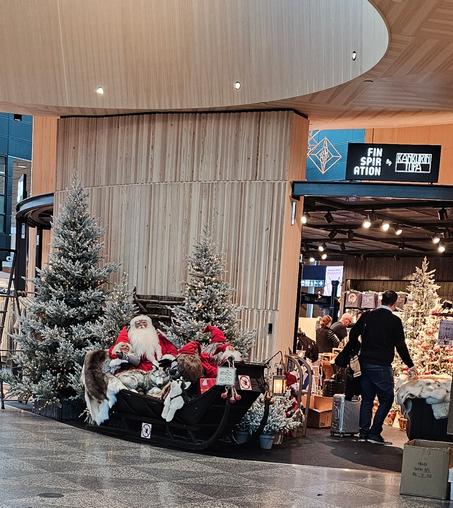 Model, life size Santa claus with Niss in a sledge surrounded by fake snow covered trees. In october, day before halloween. No Halloween decor