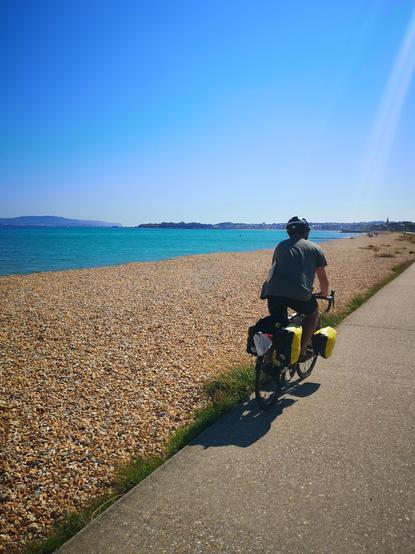 Moi sur mon vélo de rando, sur une piste cyclable en bord de plage, au sud de l'Angleterre (Devon)