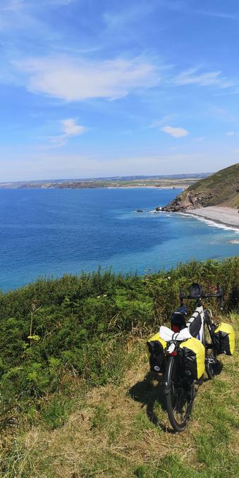 Mon vélo de rando, béquillé en bord de falaise avec un beau point de vue sur le littoral du sud de l'Angleterre (Cornouailles)