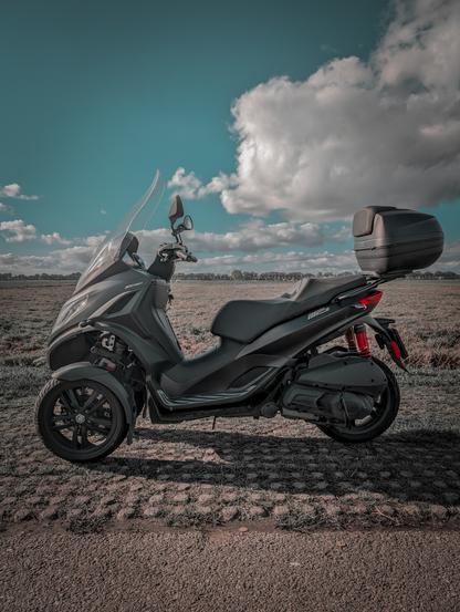 A colour modified photo of a scooter. This MP3 has been my main mode of transport on holiday and to work for the last three years.