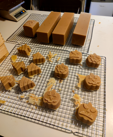 2 drying racks of soap. One has 3 logs & 1 stump (hahaha) & the other has xmas trees and jack o'lanterns with varying expressions: 2 are goofy smiling, 2 are "regular" smiling & 2 are *very* Frowny. They are not pleased with their lot in life.