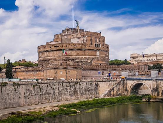 Castel Sant'Angelo a Roma, Italia. È un edificio storico cilindrico inizialmente commissionato dall'imperatore Adriano come mausoleo per sé stesso. Successivamente è stato utilizzato come fortezza e castello, e ora è un museo. La struttura è nota per la sua prominente statua di un angelo in cima.