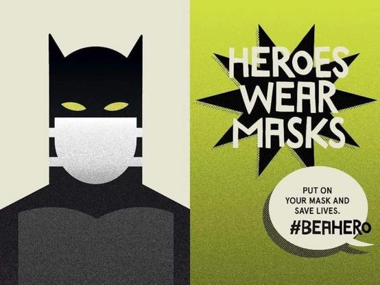 A stylized superhero figure wearing a mask is featured on the left side, with the text "HEROES WEAR MASKS" prominently displayed. The right side includes the message "PUT ON YOUR MASK AND SAVE LIVES. #BEAHERO