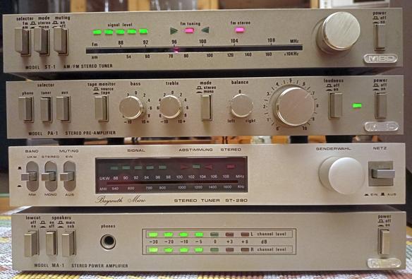 Mini-Hifi-Anlage von MBO (Importeur, nicht Hersteller) aus Tuner, Vorverstärker und Endverstärker in Betrieb. Zur Verringerung des Brummens ein Fremdgerät vom vermutlich gleichen Hersteller als Abstandshalter. Das Brummen ist stärker, wenn der Vorverstärker direkt auf dem Endverstärker steht. Mit Abstand ist es besser, ist mehrfach so beschrieben worden. Wie das Brummen gerne weiter mindern ..