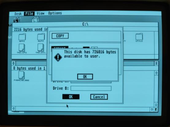 A slightly soft photo of the screen of the Atari black and white high resolution monitor, showing GEM's informational dialog at the end of the floppy disk formatting process. The dialog text reads "This disk has 726016 bytes available to user."
