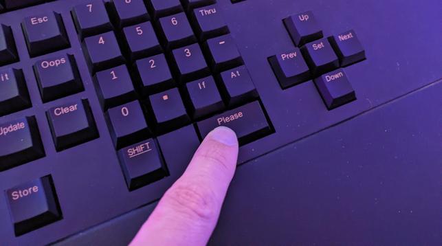 A finger pressing a key labeled "Please" on a keyboard.