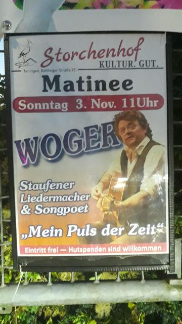 Plakat mit einem Foto des Gitarre spielenden Liedermachers und der Einladung: 
Sonntag 3.Nov. 11Uhr
Matinee im Storchenhof Kultur.Gut.
in Teningen, Bahlinger Straße 25
WOGER
Staufener Liedermacher & Songpoet
"Mein Puls der Zeit"
Eintritt frei- Hutspenden sind willkommen