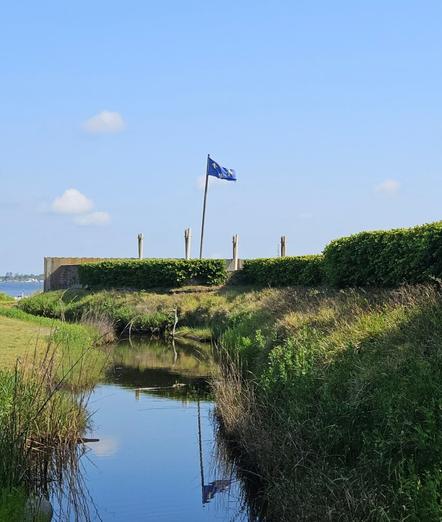 The most uncooperative flag I've encountered.  Ha! After dozens of attempts, here is the nearest I was able to capture of the blue French flag with gold "fleur-de-lis" fully extended in the wind, above the fort and moat.