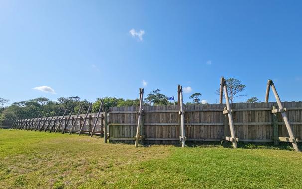 External view of the wooden wall barrier.  Here seen from the river's edge, looking towards the fort.