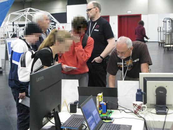 Bild: Unser Stand auf der Hack&Make2024:
Einige Jugendliche lassen sich Linux und die Videodemonstration erklären. War wieder eine sehr erfolgreiche Veranstaltung.
