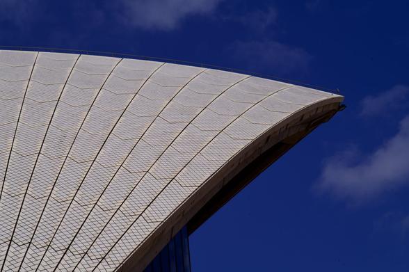 Image of the curved, tiled roof of the Sydney Opera House.  Deep blue sky is in the background.