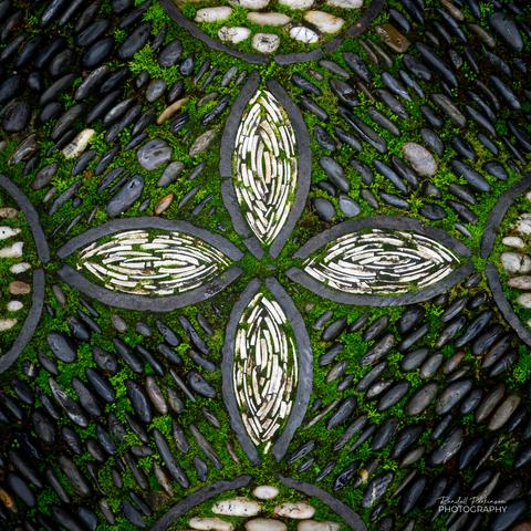 Stones of different colors and sizes with moss growing between them for a pattern on the paths of a Chinese garden.