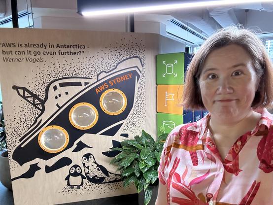 A woman in a pink shirt posing at the AWS office in Sydney