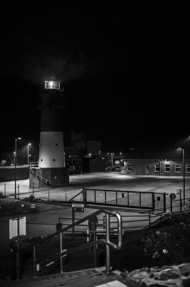 Der Leuchtturm von Büsum in schwarz-weiß bei Dunkelheit.
