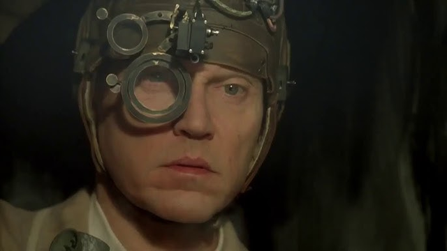 Christopher Walken as Caesar the Exterminator in 1997's oft-overlooked murine classic, "Mousehunt". 

He is wearing a helmet with magnifying lenses over his right eye.