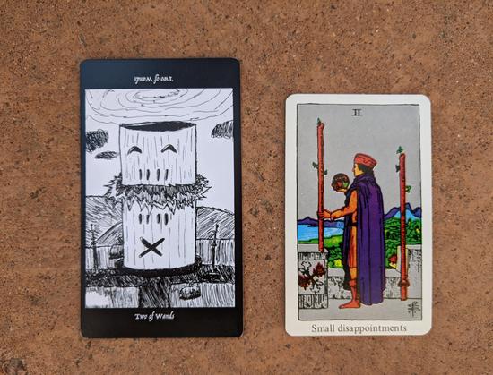 The Two of Wands from the Elsewhere Tarot, showing a rough, sketchy drawing of a large, wooden-seeming cylindrical structure exploding at its midpoint between two antennas on the ground and under a swirling vortex of clouds, alongside the Two of Wands from a janky, bootleg RWS deck, showing an explorer guy on a wall above a town and bay gazing at a globe he’s holding.