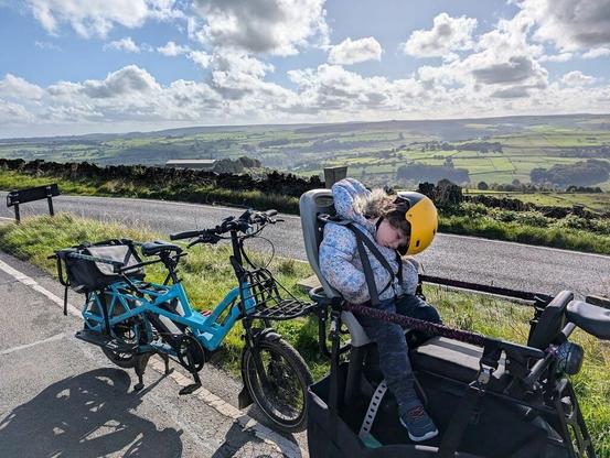 Kiddo dozing on the back of a Tern Orox. Beautiful view of the UK countryside in the background.