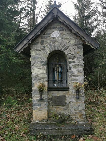 Steinernes Häuschen mit Heiligenfigur.