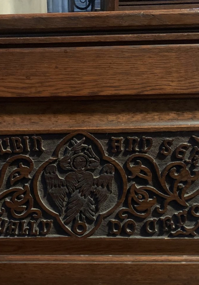 Carved wooden pew: angel is all wings plus haloed head can’t even see it’s body at all!