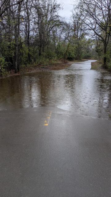 Paved trail flooded by creek