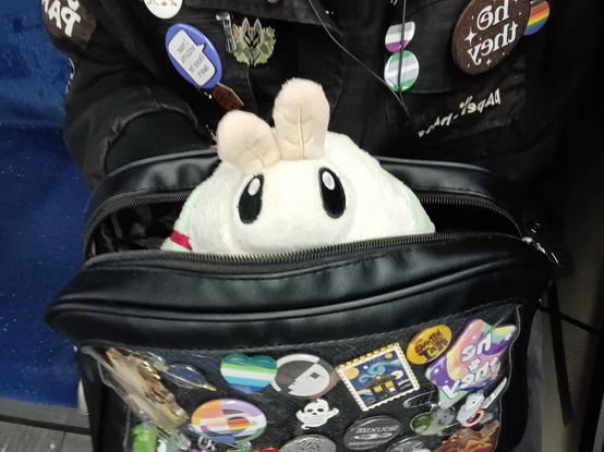A Squishable luna moth plush sticking out of an ita bag.