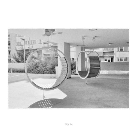 Zwei hängende Ringe, die mit Holzbrettern zu Sitzgelegenheiten verwandelt worden sind. Interior Design in den öffentlichen Flächen zwischen den Blöcken eines neuen Gemeindebaus.