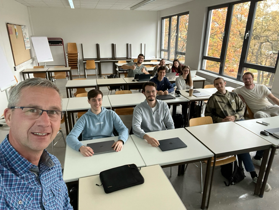 Classroom selfie at DHBW showing Thomas and a group of students.