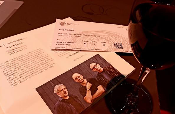 Ein glas Rotwein, die eintrittskarte und das Programmheft