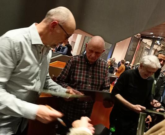 Die drei Musiker signieren Platten nach dem Konzert