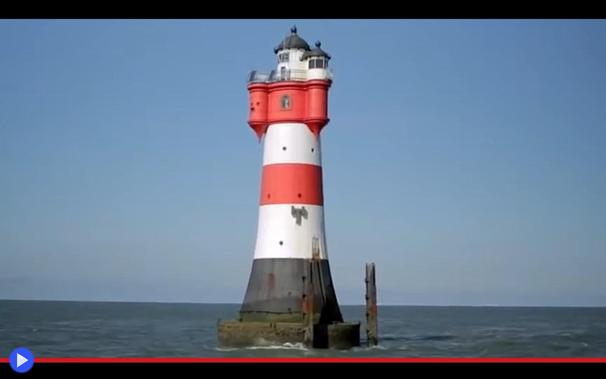 Torre in mezzo al mare aperto del famoso faro tedesco di Roter Sand, dipinto con strisce bianche, rosse ed un anello nero. La sommità dai caratteristici abbaini sporgenti ricorda la torre fatata di un ideale castello del Medioevo.