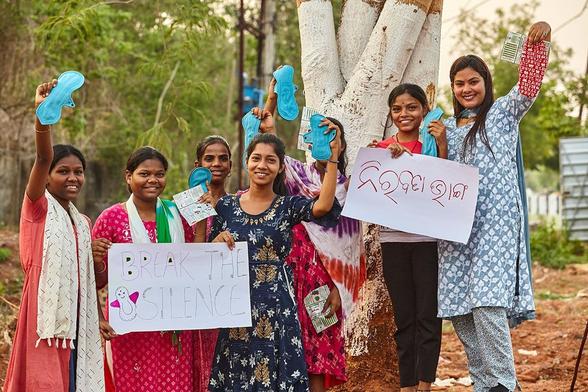 photo of Payal Patel and other girls and women smiling and holding up period pads